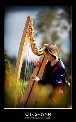 Photo of Alison playing celtic harp in Victoria garden setting