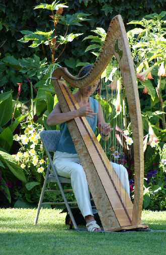 Alison playing harp in garden of Hatley Castle at Royal Roads University for family event