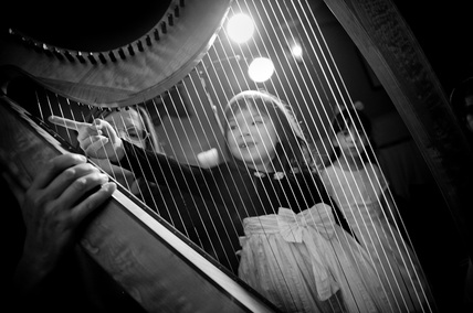 Young child trying harp at wedding at Long Beach Lodge, Tofino BC